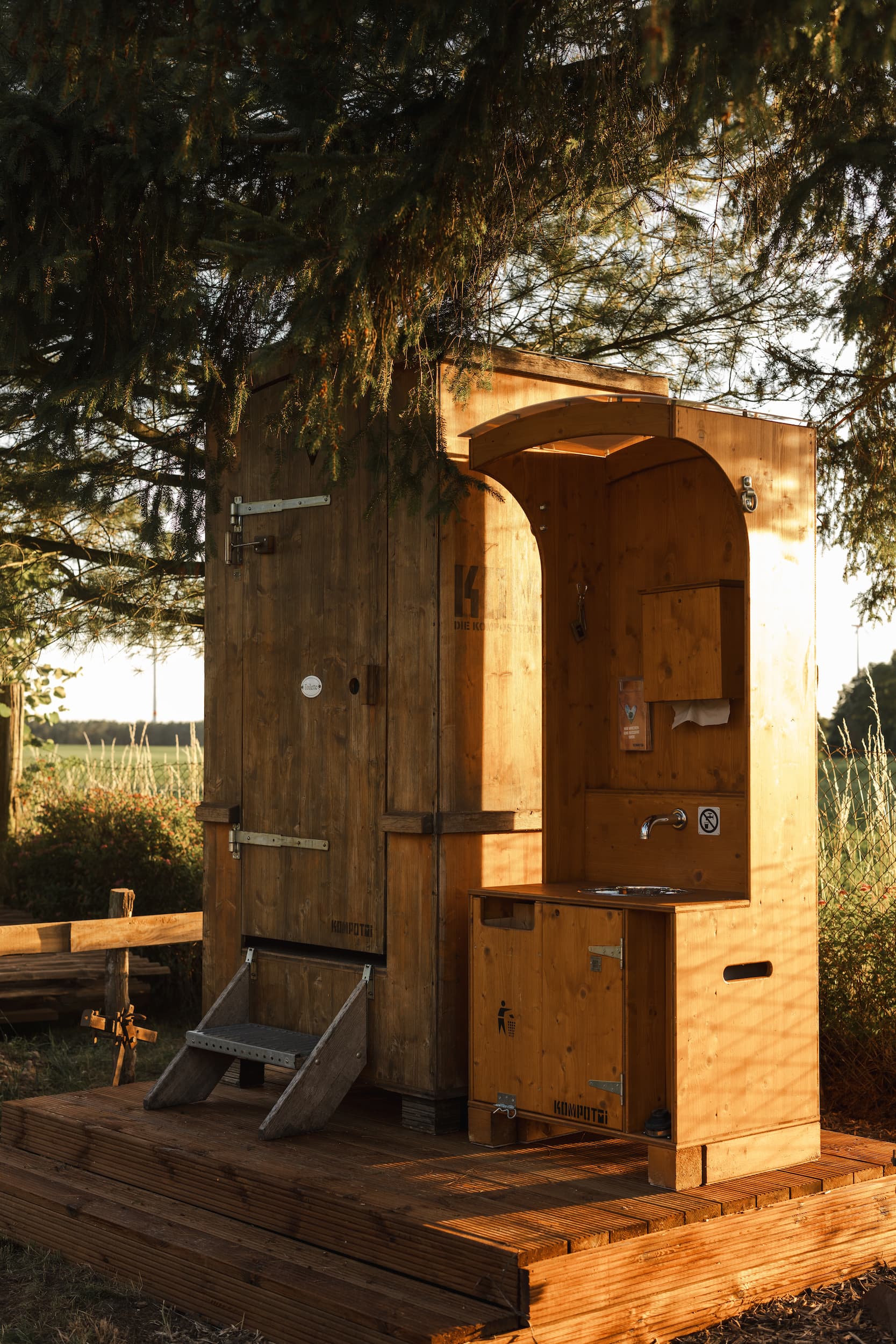 Outdoor-Toilette im Vintage-Stil – Charmante Holzhütte als Toilette bei einer Hochzeit im Grünen.